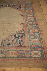 Antique Serab rug corner: beige lattice field, navy, blush Herati spandrel, wide border.