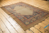 Herati corner spandrel detail on an antique Serab rug with wide blue, blush, beige border.