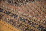 Antique Afshar carpet border detail: geometric terra cotta and navy, with secured edge.