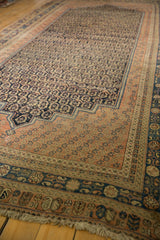 Multi-layered terra cotta and navy geometric borders on an antique Afshar carpet corner with aged fringe.