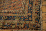 Antique Afshar rug corner showing terra cotta germinating botehs, navy borders, and visible wear.