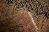 Overcast stitch, wear, and fringe on an antique Afshar carpet corner with boteh motifs.