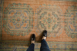 Distressed Oushak runner featuring apricot, pale blue, and mint guls with rams horn motifs.