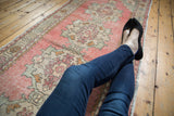 Distressed Oushak runner featuring blush, ivory, and slate Rococo-style medallions.
