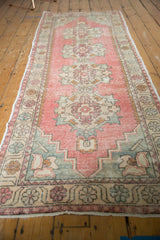 Distressed blush pink Oushak rug pile with Rococo style motifs and faint foundation.