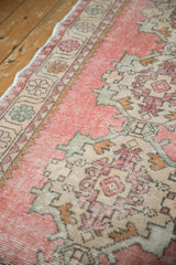 Distressed blush pink Oushak runner texture, with Rococo motifs and faded floral border.