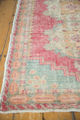 Vintage distressed Oushak runner edge, faded red, slate blue floral motifs, visible foundation.