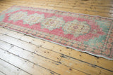 Distressed Oushak runner end, showcasing faded red and slate blue gray tones.