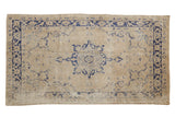 Distressed Oushak runner, ivory field with faded navy medallion and palmette border.