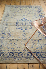 Worn pile and faded navy blue motifs on a distressed vintage Oushak rug runner.