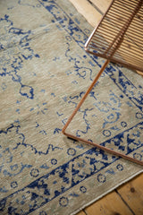 Distressed vintage Oushak rug texture with faded navy blue vine and palmette border.