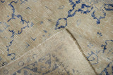 Distressed vintage Oushak rug pile showing texture, navy blue motifs, and exposed foundation.