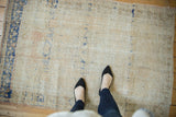 Distressed vintage Oushak rug showing faded ivory pile, subtle apricot, and soft blue abrashes.