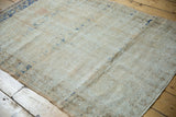 Distressed Oushak rug surface with mostly even wear, subtle abrashes, and faint navy blue.