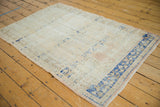Distressed Oushak rug's corner with dark navy cobalt border and pale apricot hues.
