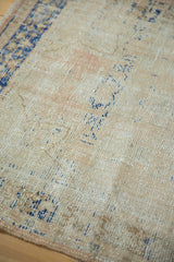 Abrashes and texture of the distressed Oushak rug, with faint apricot and dark navy cobalt blue.