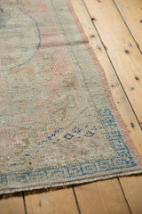 Distressed vintage Oushak runner with even wear, faint foundation, pale pink and deep blue.