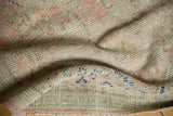 Vintage Oushak runner's folded corner, revealing distressed pile, hand-knotted foundation, and fringe.