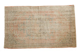 Distressed vintage Oushak rug with faded roundel medallion and soft pink hues.