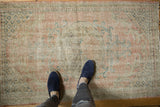 Distressed vintage Oushak rug with faded pale pink, seafoam green, and sky blue floral vinery.
