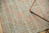 Detail of the distressed texture and even wear on a vintage Oushak rug, revealing faint pink, blue, green.
