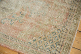 Distressed vintage Oushak rug with worn pile, faint foundation, muted pink and blue tones.