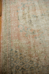 Distressed hand-knotted Oushak rug pile with visible wear to knot heads and soft pastel tones.