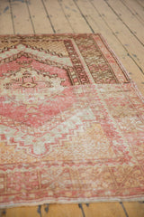 Distressed vintage Oushak rug texture with blush, beige, and bronze knot head wear.