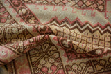 Soft, worn texture of a vintage distressed Oushak rug in faded blush and beige.