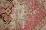 Distressed vintage Oushak rug pile revealing faint foundation, in blush, beige, and bronze.