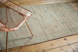 Distressed vintage Oushak rug texture with even wear, faint foundation showing through, and pale aqua tones.