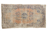 Distressed vintage Oushak rug, apricot and navy blue roundel medallion with floral vinery.