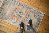 Decorative distressed vintage Oushak rug with soft apricot, beige, and navy blue.