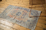 Distressed vintage Oushak rug featuring faded apricot, ivory, and cobalt blue tones with textured wear.