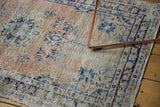 Isolated wear on a vintage Oushak rug, revealing pale apricot and navy blue texture.