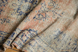 Distressed vintage Oushak rug's textured pile in faded apricot, beige, and navy blue.