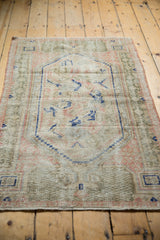 Worn pile texture of vintage Oushak rug, revealing faded ivory, pink, and cobalt blue Arts and Crafts motifs.