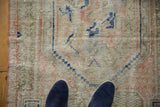 Distressed vintage Oushak rug with textured pile, ivory, navy, and pink colors.