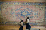 Oushak runner mid-section, featuring worn dusty blush, blue, and ivory Rococo vinery.