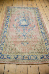 Vintage distressed Oushak runner's side border, with faded blue geometric motifs and pink worn texture.