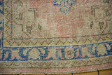 Distressed Oushak rug runner's even wear, faint foundation, dusty blush, and blue border.