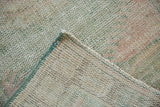 Vintage Distressed Oushak runner folded, showing worn pile with faint foundation and woven reverse.