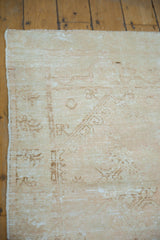 Worn pile of distressed Oushak rug corner, pale blush and sand tones, etched foundation.