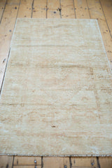Secured fringe and natural wear on the vintage Oushak rug, showcasing pale, distressed texture.
