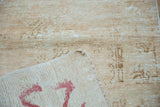 Back of vintage Oushak rug showing red painted numbers on foundation and distressed pile.