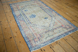 Distressed Oushak rug featuring dusty cobalt blue border and faded Arts and Crafts motifs.