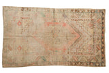 Distressed vintage Oushak rug with a pale blush center medallion and soft neutral tones.