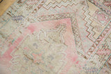 Distressed Oushak rug, showing pale blush stepped spandrel and worn geometric border.