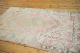 Distressed Oushak rug detail: faded blush spandrels, coffee brown serrated leaf border.