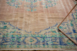 Distressed dusty rose vintage carpet with faded blue and mint green palmette border.